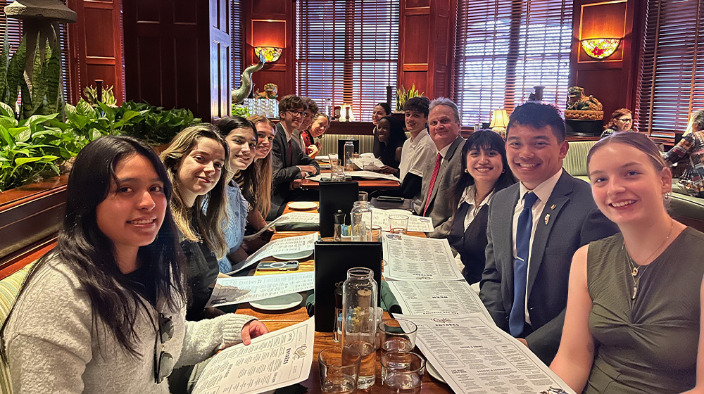 Dean Schraeder sits with students in the DC Program